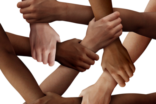 Image of people of diverse skin tones holding hands and wrists