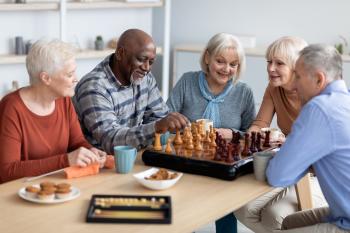 Group of older men and women playing a game of chess. 