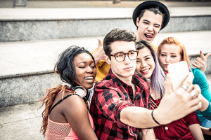 A group of teens taking a selfie with a cell phone